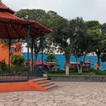 A través de la implementación de la Ley de Imagen Urbana —publicada el 5 de octubre de 2023 y considerada la primera en su tipo a nivel nacional— el gobierno de Julio Menchaca Salazar ha desplegado una estrategia territorial que prioriza la sensibilización social, la corresponsabilidad y el orden en el entorno urbano. Al respecto, el director general de Imagen y Desarrollo Urbano Sostenible, Horacio Castañeda Reyes, de la Secretaría de Infraestructura Pública y Desarrollo Urbano Sostenible (SIPDUS), explicó que esta normativa no está enfocada en construir nueva infraestructura, sino en dignificar y mantener los espacios existentes. “La intención de esta ley es involucrar a los municipios, al estado, pero sobre todo a la población en que los espacios deben conservarse de una manera digna y en funcionamiento no por una administración, sino por el resto de la vida de los ciudadanos. Es el fundamento general de la Ley de Imagen Urbana, el rescate de los espacios públicos y la dignificación de los mismos”, señaló. En ese sentido, el eje central de la estrategia ha sido involucrar activamente a la población. La meta es clara: que parques, calles, fachadas y espacios comunitarios no dependan únicamente de la autoridad, sino del cuidado cotidiano de quienes los utilizan. Como parte de estas acciones, el gobierno de Hidalgo ha visitado 70 municipios, donde se realizan diagnósticos con una visión externa —similar a la de un turista— para detectar áreas de oportunidad que, por costumbre, suelen pasar desapercibidas por autoridades y habitantes. Este ejercicio ha permitido identificar problemáticas como contaminación visual, desorden en la publicidad o deterioro de espacios públicos, generando recomendaciones puntuales para cada localidad. Uno de los hallazgos más relevantes ha sido que los espacios intervenidos con participación comunitaria tienden a conservarse en mejores condiciones. Ejemplo de ello es la rehabilitación de canchas deportivas en distintos municipios, donde vecinos —especialmente jóvenes— aportaron mano de obra y gestión de materiales. El resultado: espacios cuidados, sin vandalismo y con mayor sentido de pertenencia. El funcionario explicó que los municipios como Zempoala, Tasquillo, Mineral del Monte, Huasca y Mineral del Chico han destacado por adoptar la ley con resultados visibles: Más de mil 300 fachadas rehabilitadas en Zempoala mediante esquemas de colaboración; retiro de publicidad irregular y mejora del orden visual; intervención en postes, señalética y espacios públicos. Pero más allá de la normativa, el gobierno estatal reconoce que el mayor reto es cultural: romper la idea de que el espacio público es responsabilidad exclusiva de la autoridad. “Estamos invitando a los ciudadanos a que sus reglamentos de imagen urbana, de obra pública, se adapten a lo que es la Ley de Imagen Urbana y vayamos de la mano. Realmente no es algo nuevo lo que estamos poniendo en la Ley de Imagen Urbana, es poner orden a lo que ya existe”, puntualizó. La estrategia también contempla la adaptación de reglamentos municipales y el respeto a las particularidades de cada región, reconociendo que la imagen urbana no es igual en contextos rurales y urbanos. Con esta política, Hidalgo no sólo busca mejorar la apariencia de sus municipios, sino construir entornos más ordenados, dignos y sostenibles, donde la ciudadanía sea protagonista.