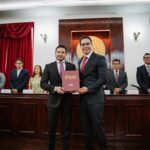 Durante la Tercera Sesión Solemne Pública del H. Ayuntamiento de Pachuca el presidente municipal Jorge Reyes entregó el informe sobre el estado que guarda la administración pública municipal, correspondiente al segundo año de gobierno, en cumplimiento con lo establecido por la normatividad. En su mensaje, Jorge Reyes destacó que estos dos años han representado una etapa de transformación para Pachuca, con acciones encaminadas a poner orden en la administración municipal, recuperar los servicios públicos y atender necesidades que durante años permanecieron pendientes. El presidente municipal señaló que los resultados alcanzados son producto del trabajo coordinado entre las distintas áreas del gobierno y de una visión que coloca a Pachuca y a sus habitantes en el centro de las decisiones públicas. Asimismo, refrendó el compromiso de mantener una administración responsable, cercana y transparente, que dé continuidad a las acciones emprendidas durante estos dos primeros años y consolide los cambios que requiere la ciudad. Al recibir la glosa del informe, Alejandro Velázquez Mendoza, secretario del Despacho del gobernador de Hidalgo, Julio Menchaca, reconoció la labor realizada por el Ayuntamiento y destacó la importancia de los resultados alcanzados durante este segundo año de administración. Del mismo modo, reiteró la disposición de mantener la coordinación entre el Gobierno Federal, el Gobierno Estatal y el Ayuntamiento de Pachuca para fortalecer las acciones que atienden las necesidades de la capital hidalguense y contribuyen a su desarrollo